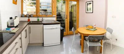 a kitchen with a wooden table and a small table with chairs at Bwthyn Gweilch in Machynlleth