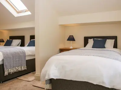 a bedroom with two beds and a skylight at Conkers' Cottage in Church Stretton