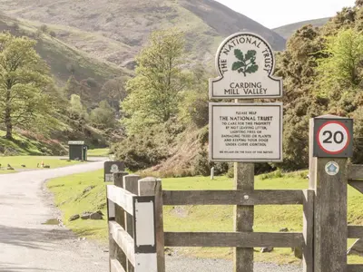 a sign on a fence next to a road at Conkers' Cottage in Church Stretton