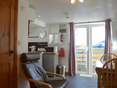 a kitchen with a chair and a table with a microwave at Paramount Cottage in Farden