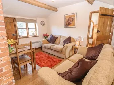 a living room with a couch and a table at Top Farm Cottage in Oswestry