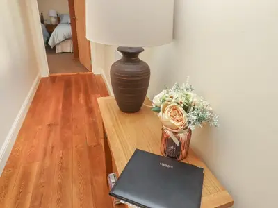 a table with a lamp and a book on it at Top Farm Lodge in Oswestry