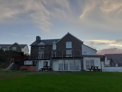 a large house with a deck on the side of it at Bryncarnedd Farmhouse in Aberystwyth