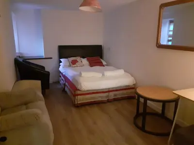 a small bedroom with a bed and a chair at Bryncarnedd Farmhouse in Aberystwyth