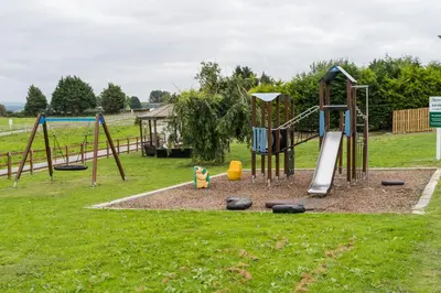 a park with a playground with a swing set at Bryncarnedd Farmhouse in Aberystwyth