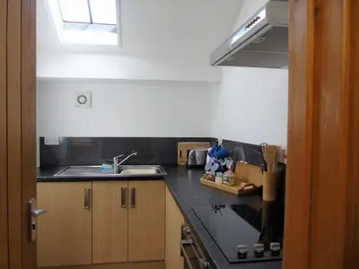 a kitchen with a black counter top and a sink at Gwilym's Stable in Builth Wells