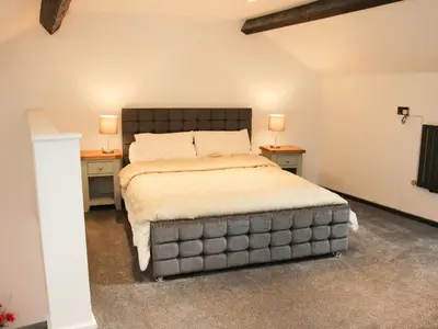 a bedroom with a large bed with two night stands at Bank House Barn in Shrewsbury