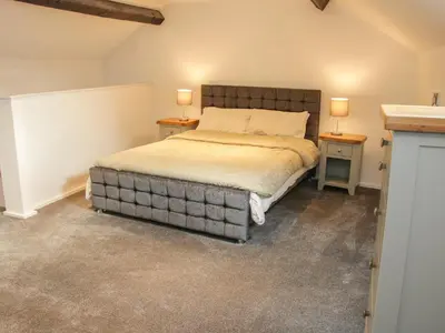 a bedroom with a large bed with two night stands at Bank House Barn in Shrewsbury