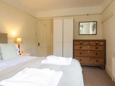 a bedroom with a bed with a dresser and a mirror at Mor Edrin in Talsarnau