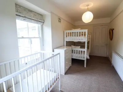 a baby room with a crib and a bunk bed at Mor Edrin in Talsarnau