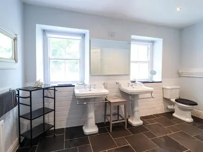 a bathroom with two sinks and a toilet at Mor Edrin in Talsarnau
