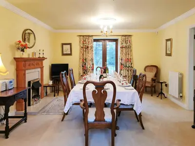 a dining room with a table and a fireplace at Holly Barn in Selattyn