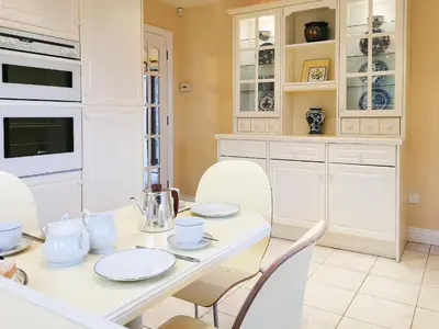 a kitchen with a white table and white chairs at Holly Barn in Selattyn