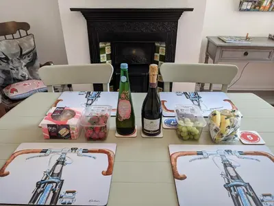 a table with two bottles of wine and food at Luxury townhouse in town centre, views, river walk, Free Parking in Shrewsbury