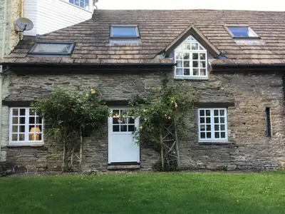 a stone house with a white door and windows at The Hillis Farmhouse - 6 Bed - Sleeps 11 - Pets in Brecon