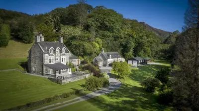 an aerial view of a large house on a green field at Tan Llan in Dolgellau