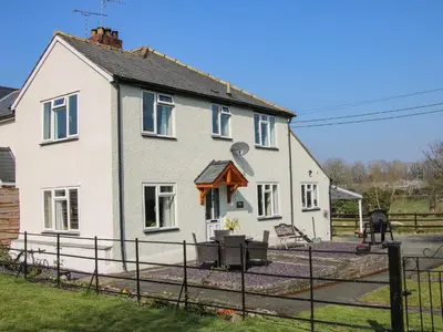 a white house with a fence in front of it at Belmont Bridge in Oswestry