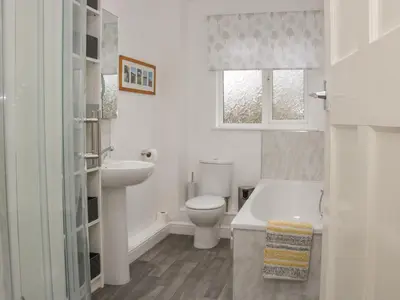 a white bathroom with a toilet and a sink at Belmont Bridge in Oswestry