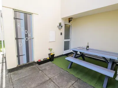 a picnic table and a bench on a patio at Redwood in Harlech