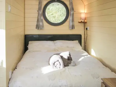 a bed in a small room with a window at Stapeley Pod in Shrewsbury