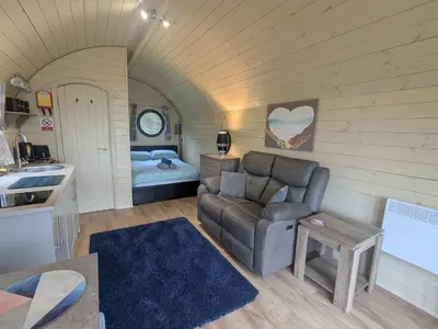 a living room with a couch and a bed at Stapeley Pod in Shrewsbury