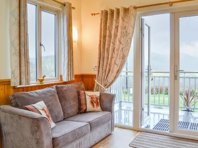 a living room with a couch and a sliding glass door at Tyncoed - Uk32238 in Lower Chapel
