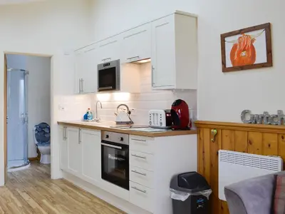 a kitchen with white cabinets and a stove top oven at Tyncoed - Uk32238 in Lower Chapel