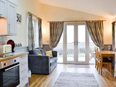 a kitchen and living room with a couch and a table at Ty Nant - Uk32239 in Lower Chapel