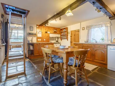 a kitchen with a wooden table and chairs at Pen Y Crug in Beulah