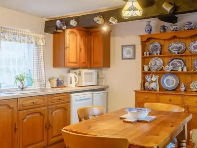 a kitchen with wooden cabinets and a wooden table at Pen Y Crug in Beulah