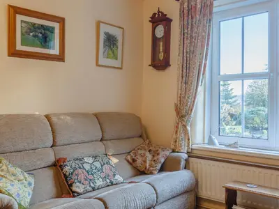 a living room with a couch and a window at Pen Y Crug in Beulah