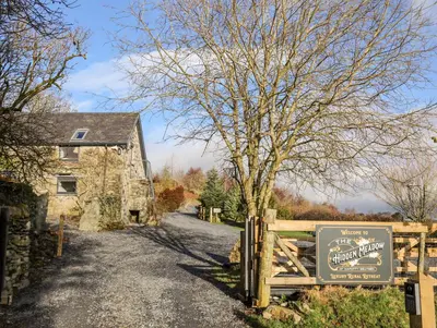 a sign on a fence next to a house at Drovers Barn in Corwen