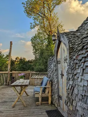 an old shed with a chair and a table on a deck at HOBLEY House Holiday in Craven Arms