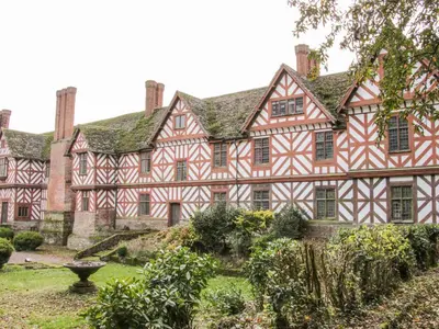 an exterior view of a large house with a yard at The Generals Quarters at Pitchford Estate in Shrewsbury