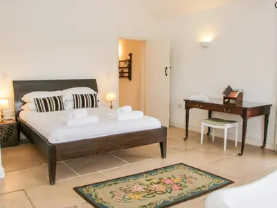 a bedroom with a bed and a desk and a table at Treehouse Barn at Pitchford Estate in Shrewsbury