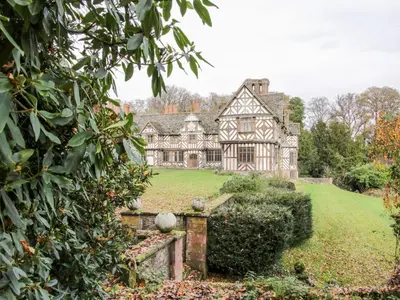 an old house in the middle of a yard at Treehouse Barn at Pitchford Estate in Shrewsbury