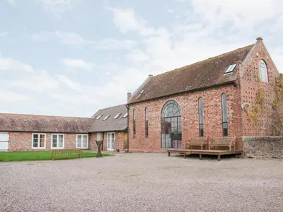 an old brick building with a bench in front of it at Windy Mundy Farm at Pitchford Estate in Shrewsbury