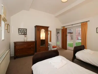 a bedroom with two beds and a dresser at Windy Mundy Farm at Pitchford Estate in Shrewsbury