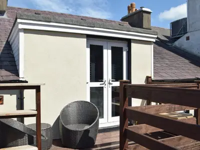 an extension to a house with a door on a deck at Bristol House in New Quay