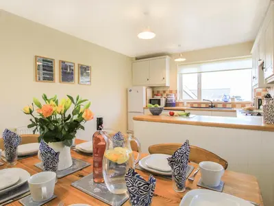a kitchen with a table with plates and flowers on it at Garnedd Lwyd in Harlech