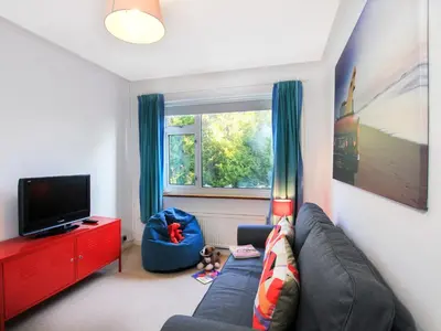 a living room with a blue couch and a window at Garnedd Lwyd in Harlech