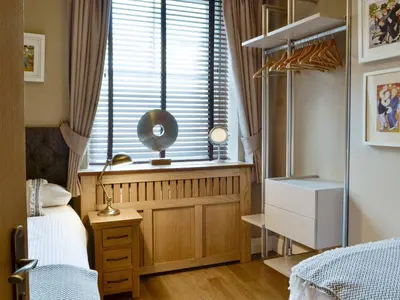 a bedroom with a window with a bed and a desk at The Apartment in Brecon