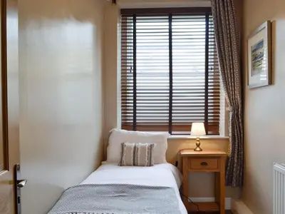 a small bedroom with a bed and a window at The Apartment in Brecon