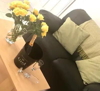 a vase of yellow flowers on a table next to a couch at Wisteria Cottages are self catering cottages in a beautiful village location in Dorrington