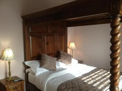 a bedroom with a large bed with a wooden headboard at Brigands Inn in Mallwyd