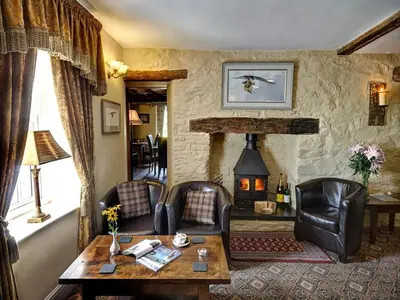 a living room with a table and chairs and a fireplace at Brigands Inn in Mallwyd