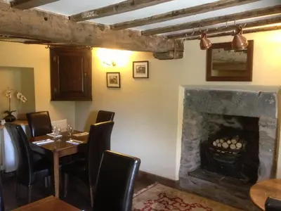 a dining room with a fireplace and a table and chairs at Brigands Inn in Mallwyd
