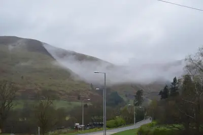a misty mountain with a road and street lights at Brigands Inn in Mallwyd