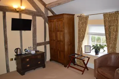 a living room with a tv and a wooden cabinet at Brigands Inn in Mallwyd