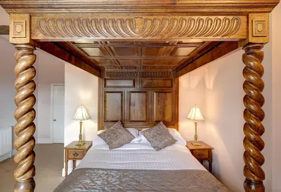 a large wooden canopy bed in a bedroom at Brigands Inn in Mallwyd